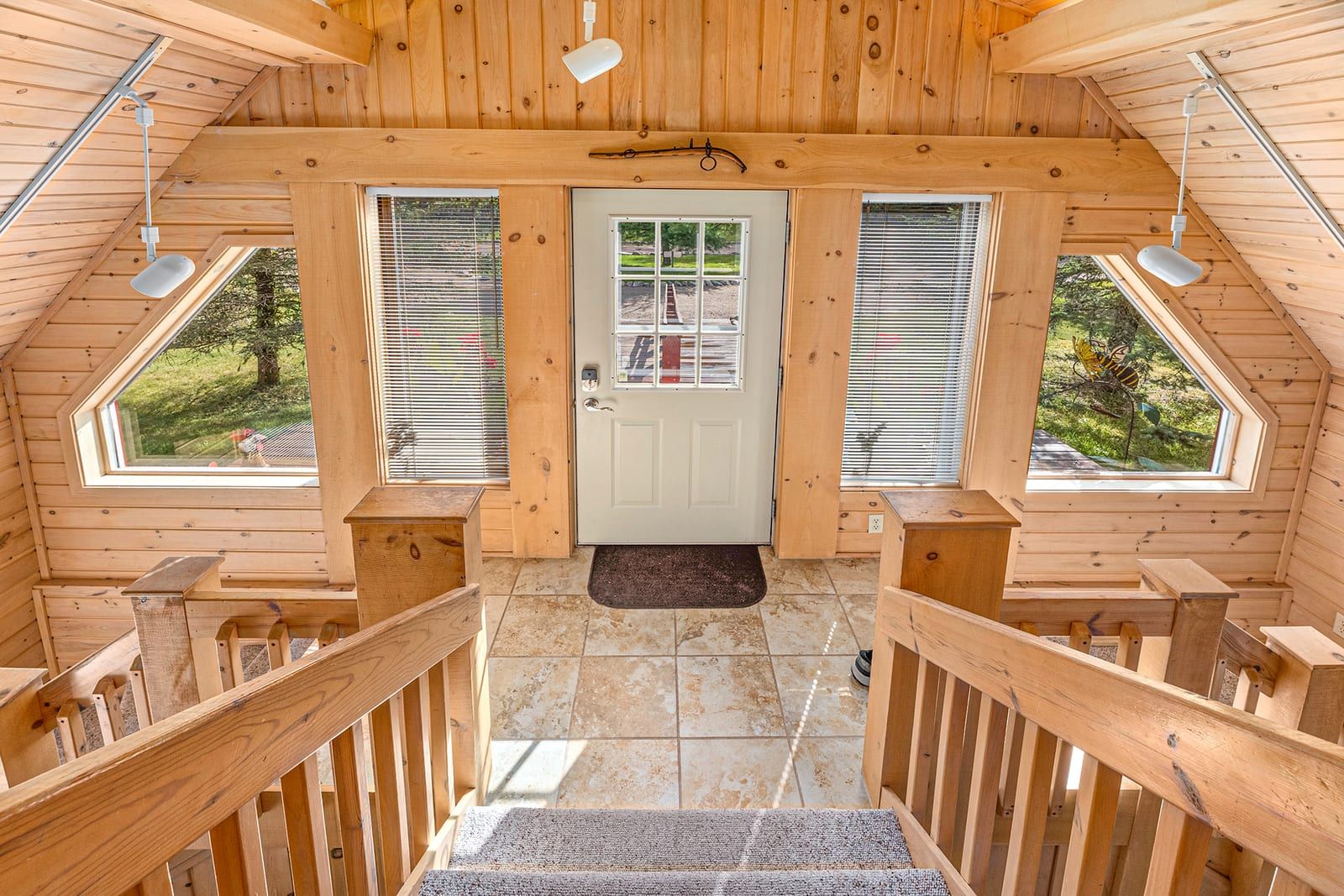 Entry foyer viewed from above with pine railing