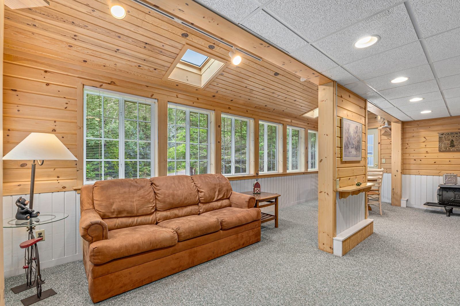 Lower level family room with sofa and skylights