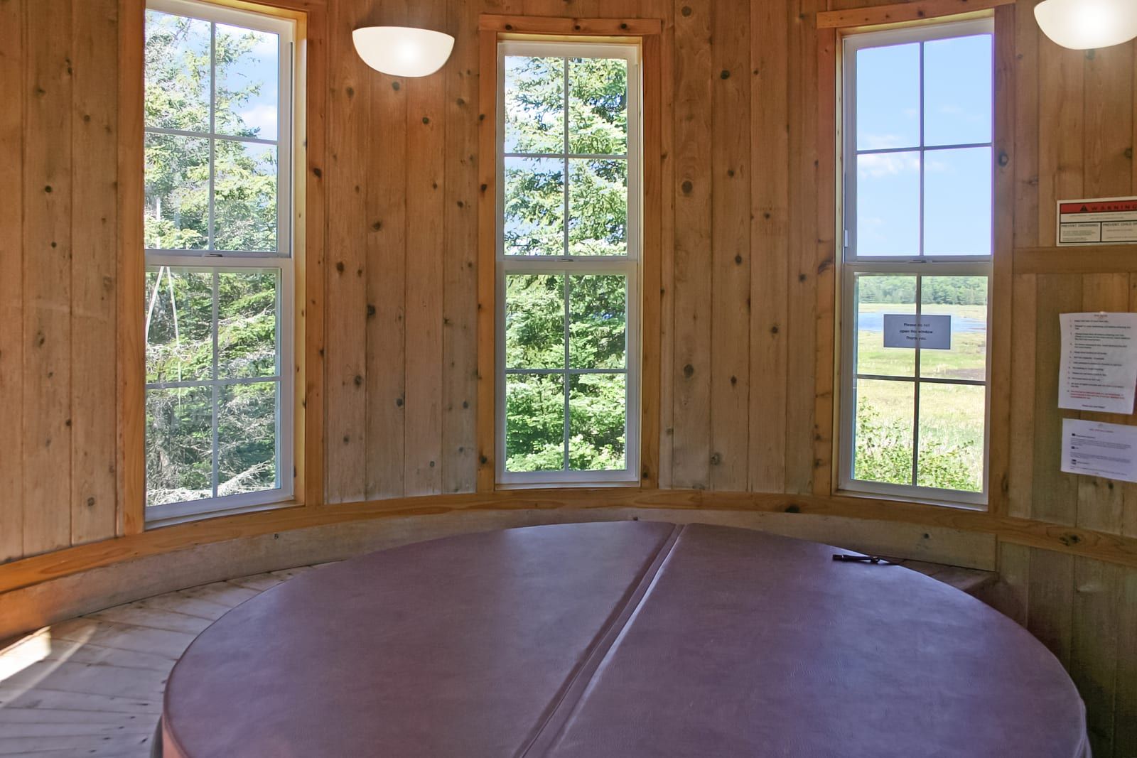 Silo hot tub covered, with lake views through windows