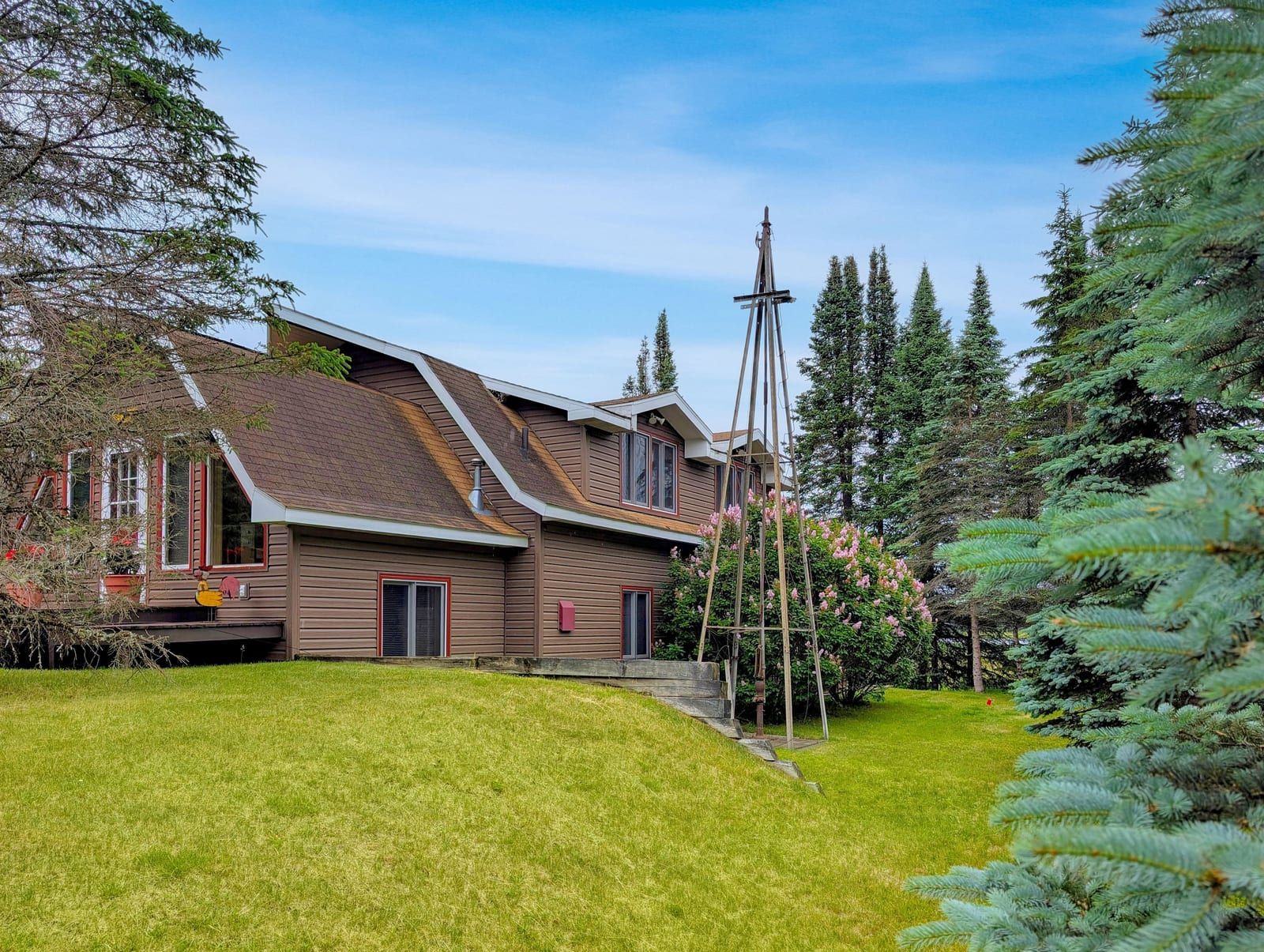 Harlequin Haven exterior with red railing and green lawn