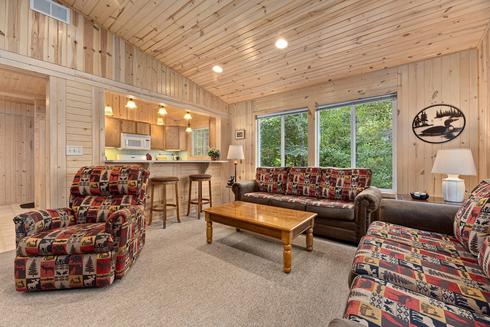 Open living area with kitchen bar and forest views