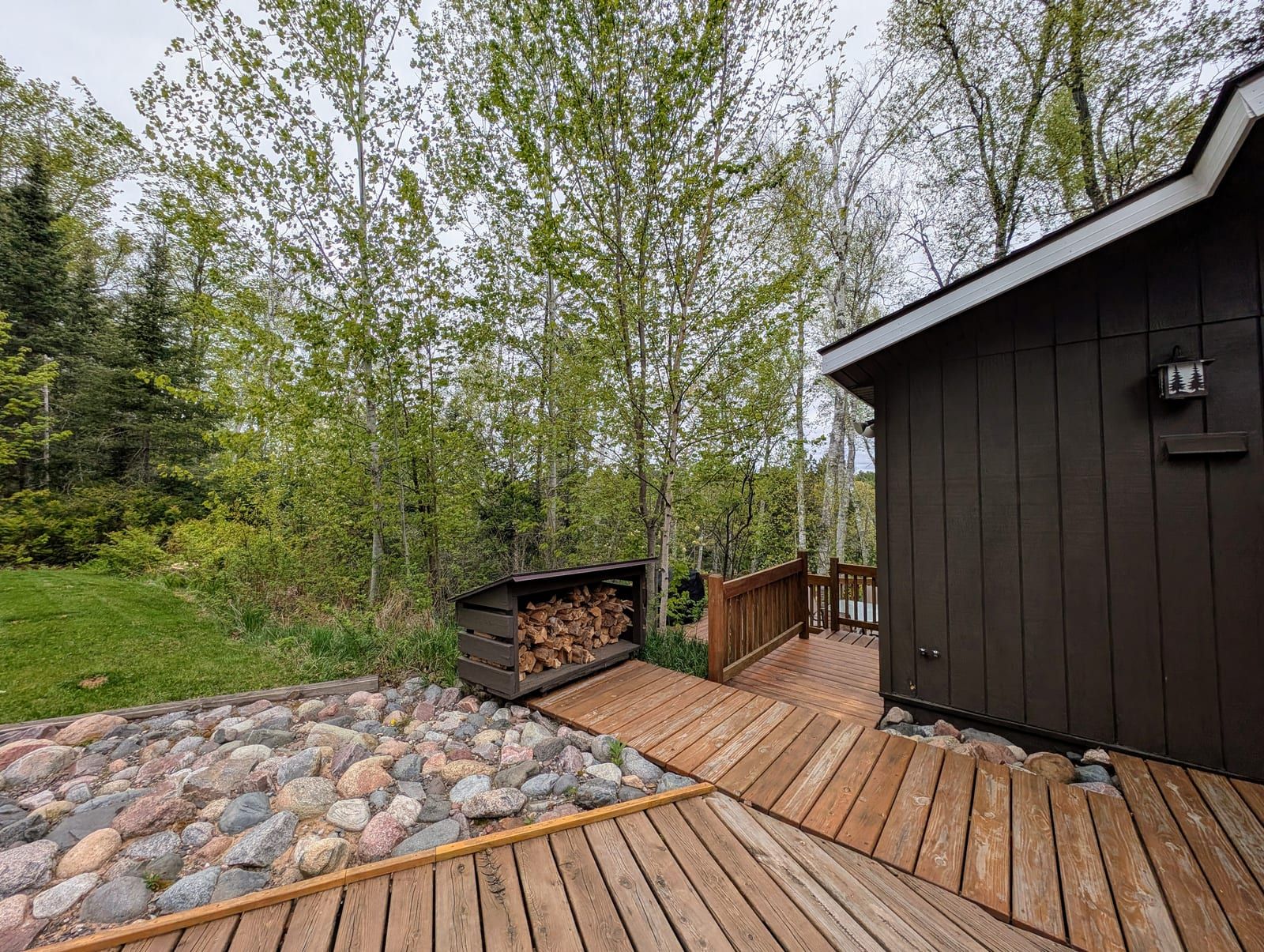 Firewood storage and deck walkway with birch trees