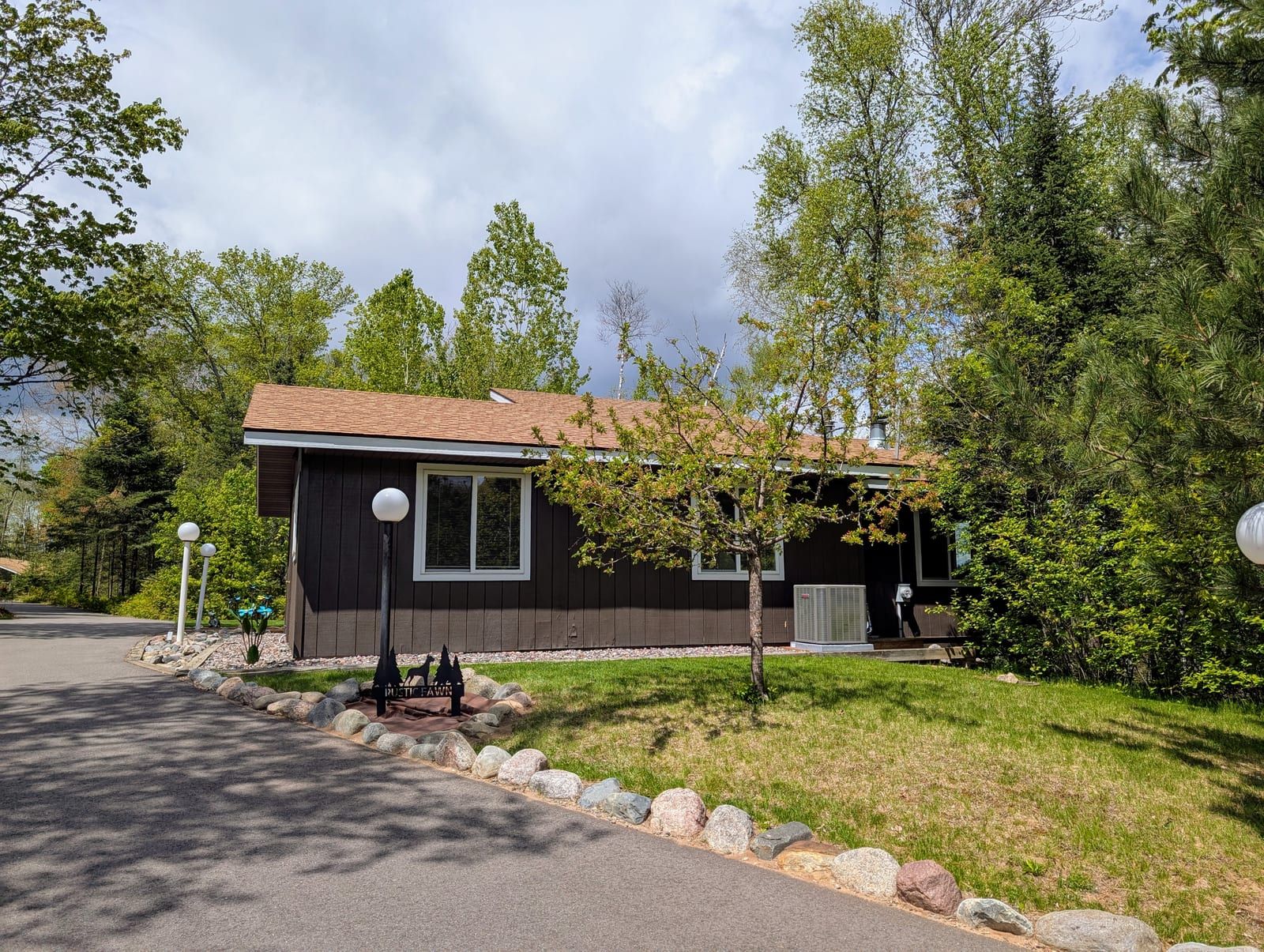 Rustic Fawn front approach with driveway and landscaping